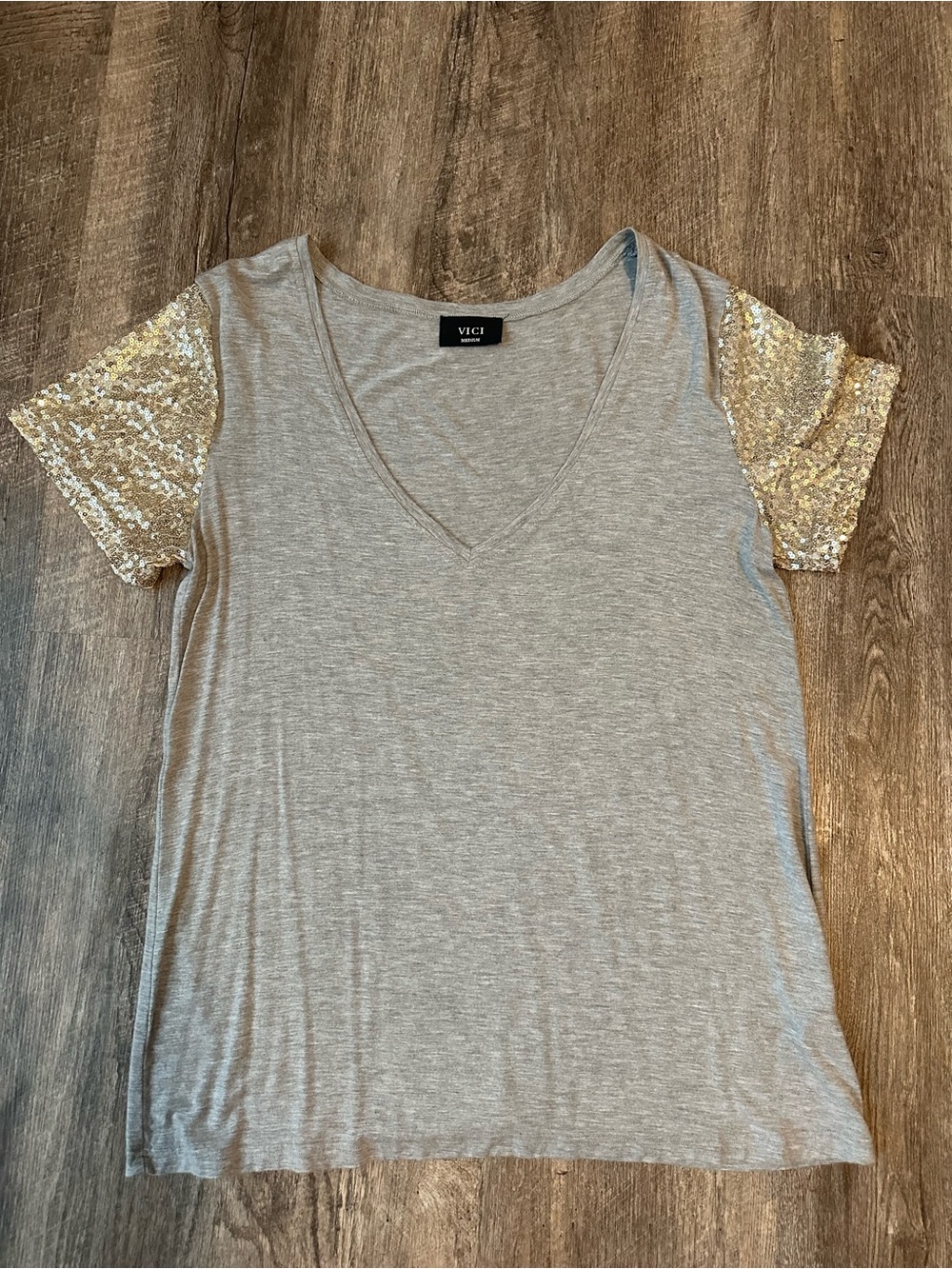 Beautiful grey v neck tee with a gold sequin sleeve!